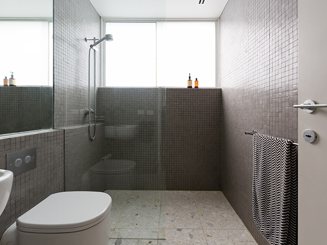 Walk-in-Dusche bodeneben mit einem Glaselement an der Wand befestigt