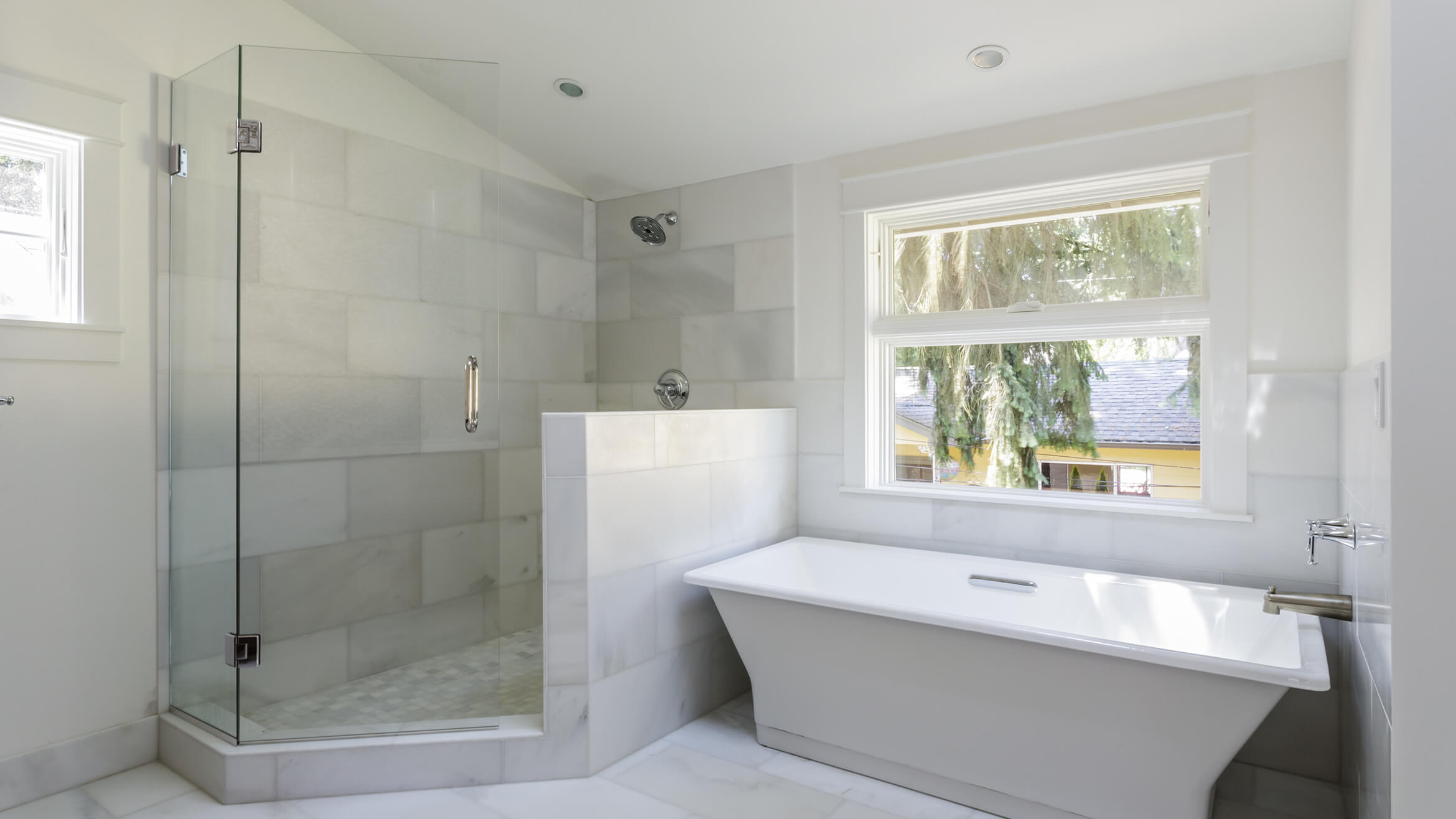 Eckdusche mit Pendeltür an verkürzter Wand neben Badewanne