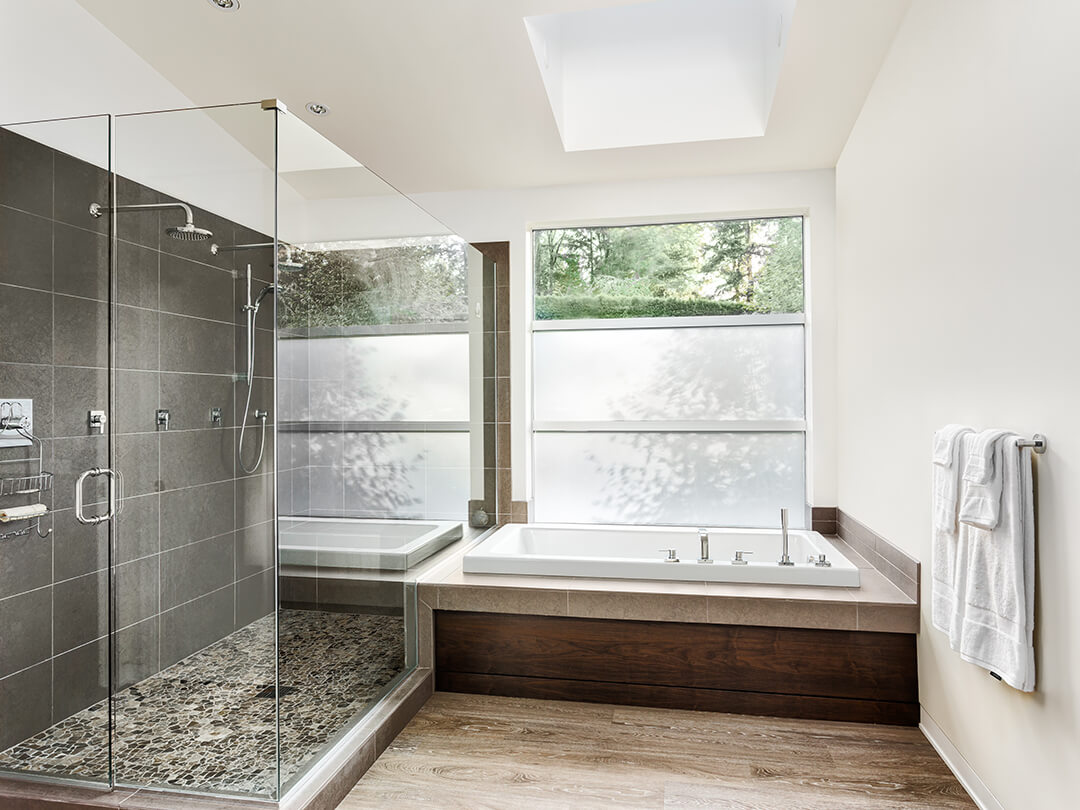 Große Eckdusche mit einer Tür neben großer Badewanne