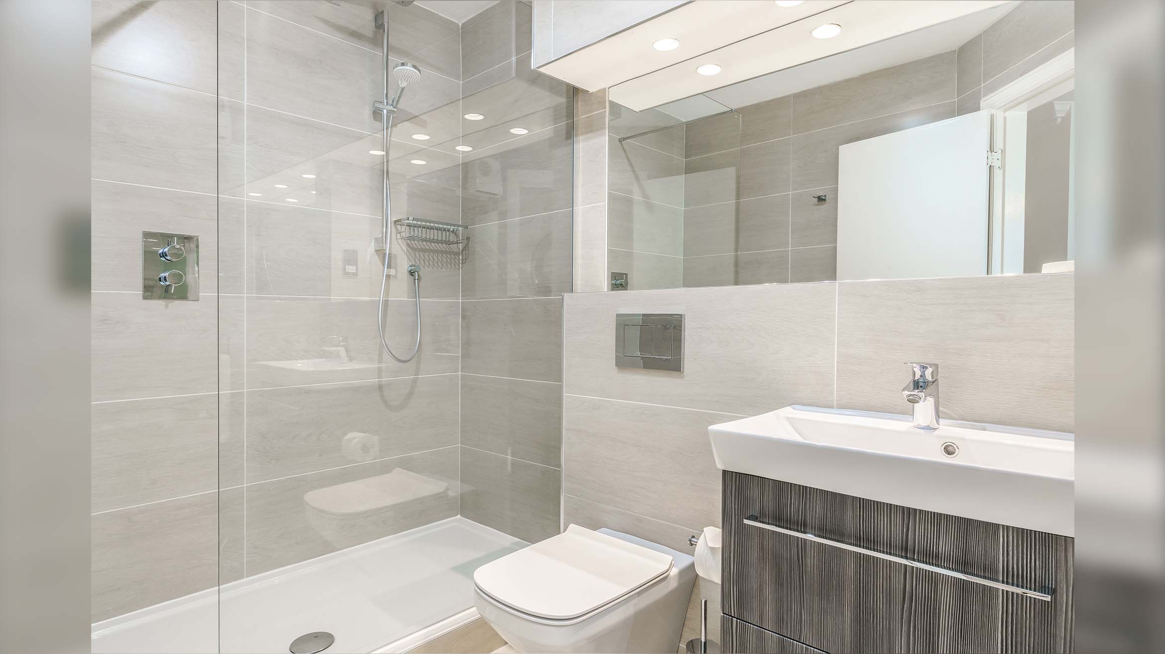 Walk-in-Dusche auf Duschtasse als Eckeinbau neben Toilette in kleinem Badezimmer 