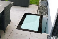 Begehbarer Glasboden mit schwarzem Rand aus VSG als Kellerschachtabdeckung Outdoor