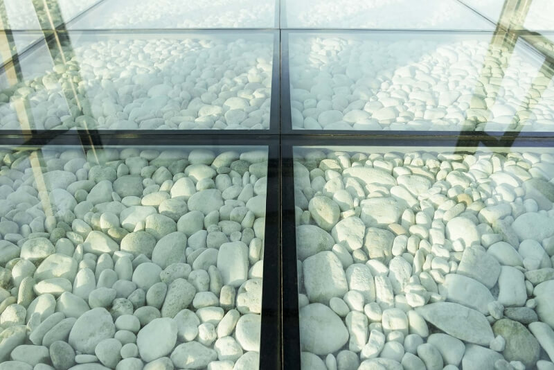 Begehbares Glas über Outdoorsteine mit schwarzen Kanten