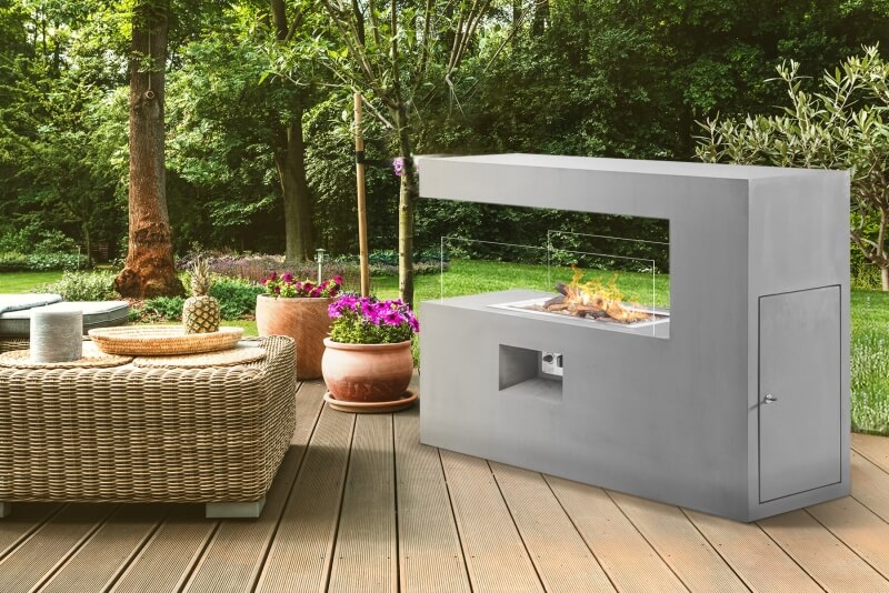 Dekokamin aus Edelstahl mit seitlicher Öffnung als Highlight im Garten neben Sitzgruppe
