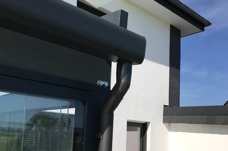 Detailansicht Terrassenüberdachung aus Spezialglas mit schwarzer Regenrinne sorgfältiger Verarbeitung und hoher statischer Belastbarkeit