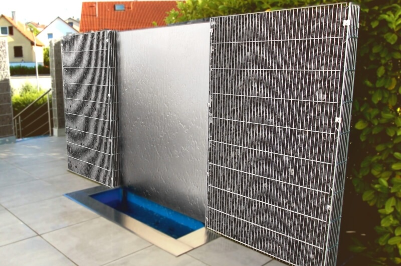 Edelstahl-Wasserwand zwischen Gabionen