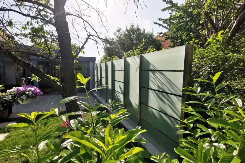 Nahaufnahme Glaszaun verschraubt auf Pflastersteinen