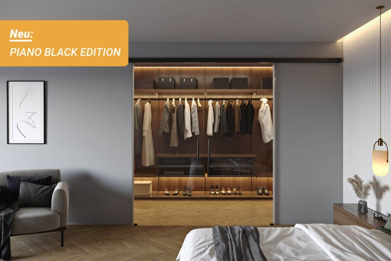 Softclose Glasschiebetür mit hochwertigen Edelstahlkomponenten in schwarz trennt Garderobe ab