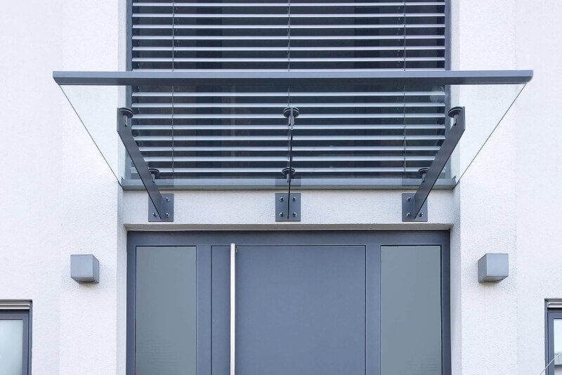 Vordach auf Edelstahlschwertern farblich passend zur Regenrinne