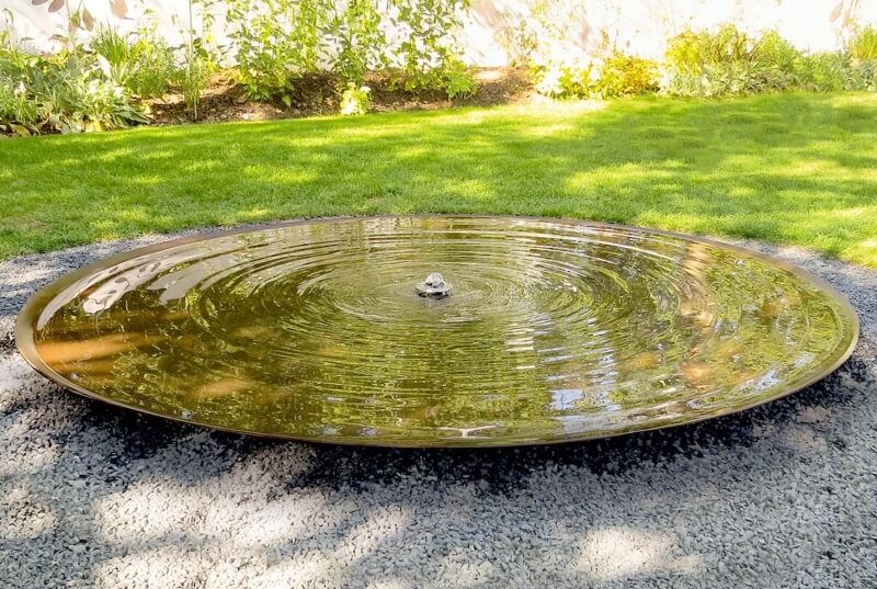 Wasserschalenbrunnen in einem Kiesbeet
