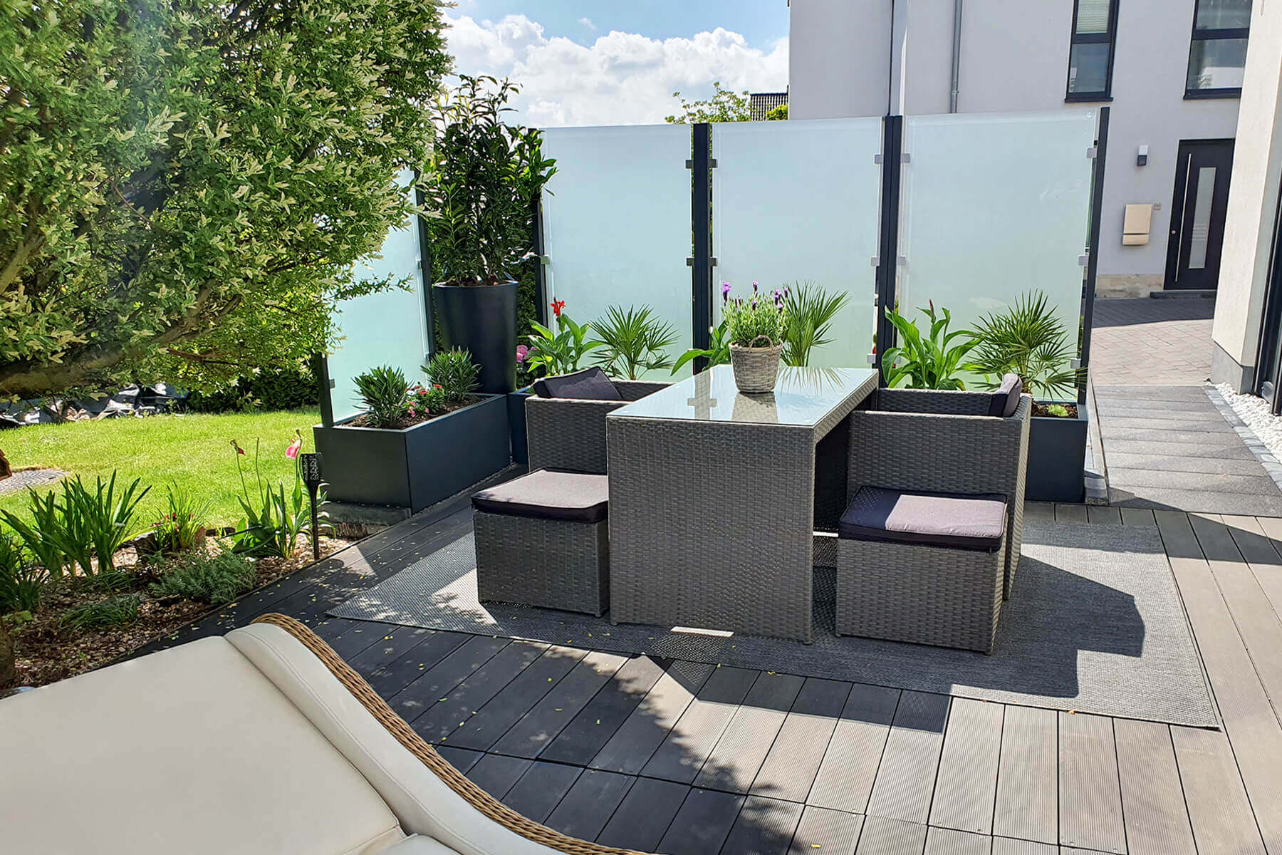 Mehrere Pflanzkästen mit Sichtschutz nebeneinander als Trennwand im Garten