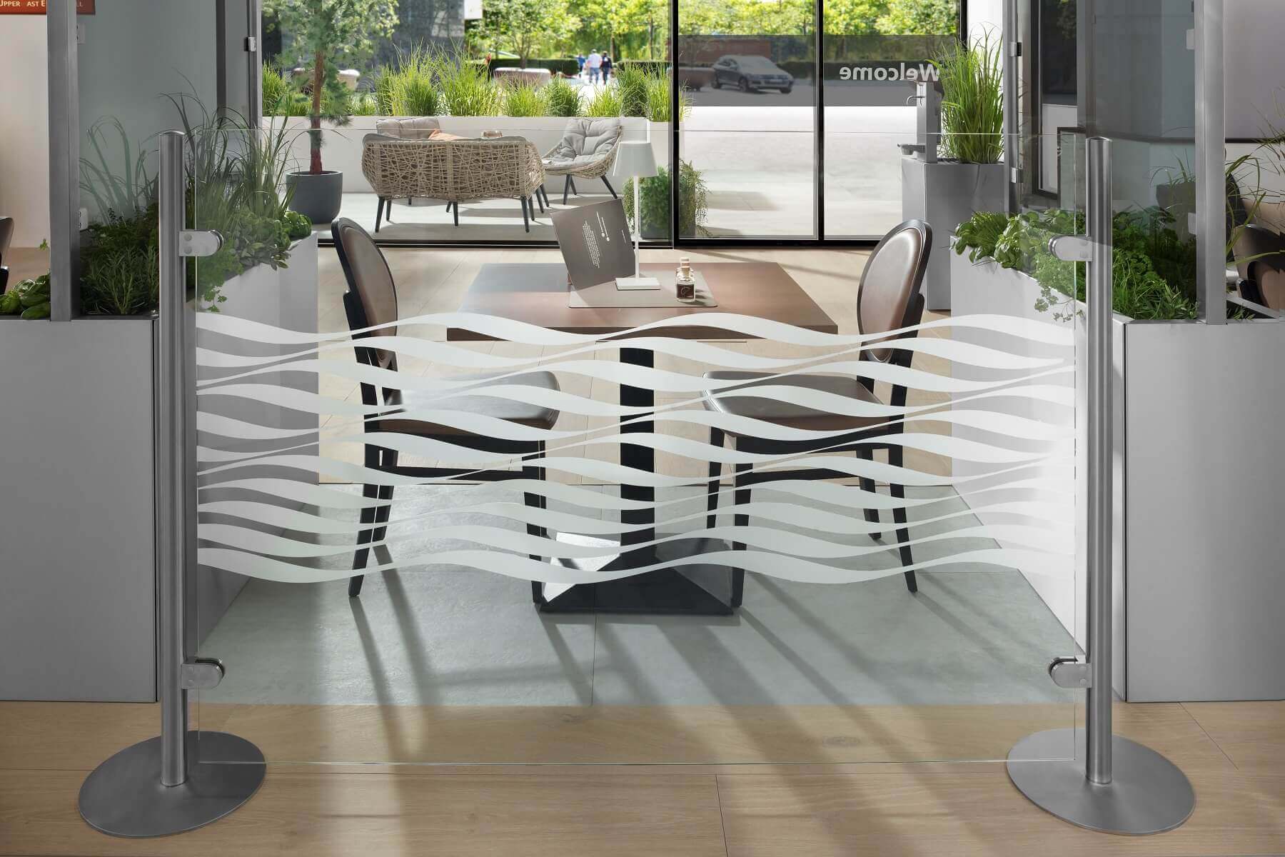 Stellwand aus Glas mit Tellerfüßen als Trennwand im Restaurant