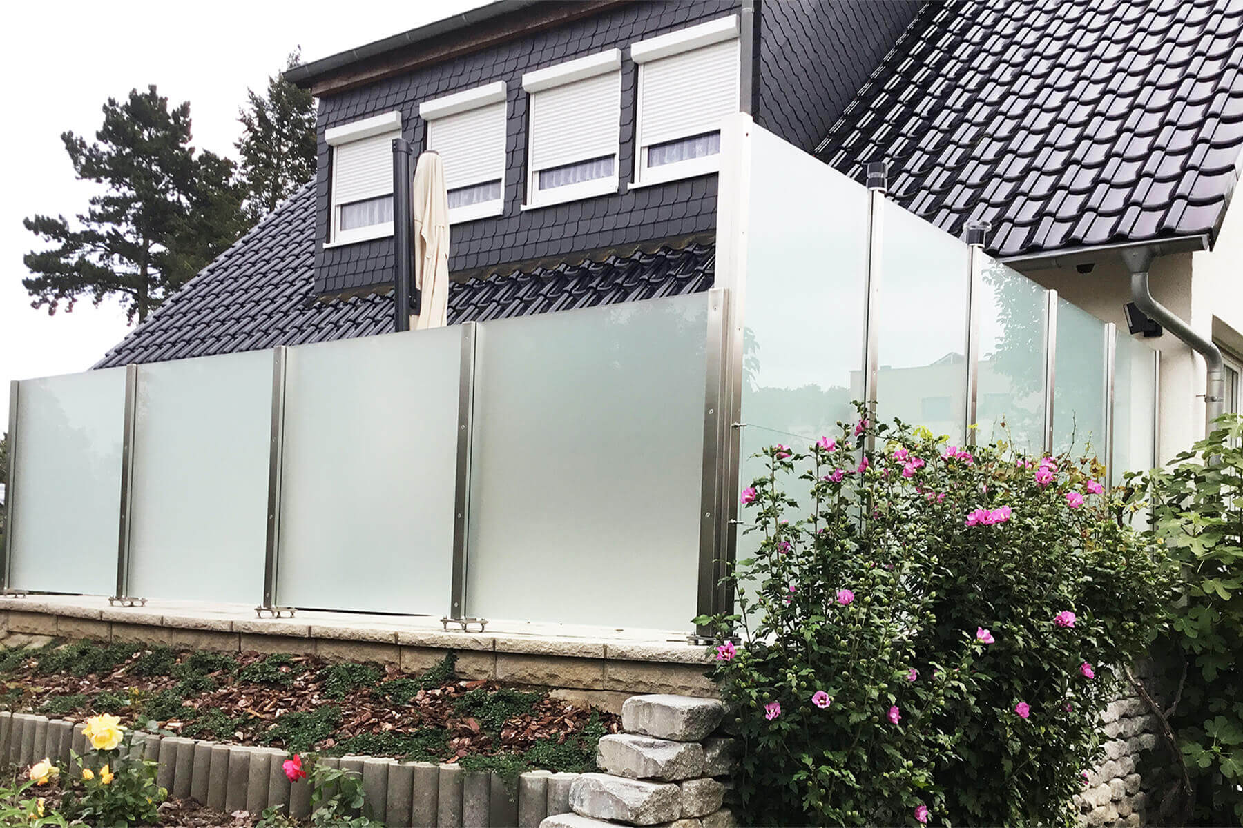 Moderner blickdichter Glaszaun als Wind- und Sichtschutz für den Garten oder Terasse auch geeignet für Untergründe mit Gefälle